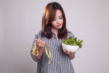 Ölçme bant ve salata ile mutsuz Asyalı kadın.