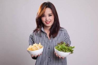 Patates kızartması ve salata ile genç Asyalı kadın.