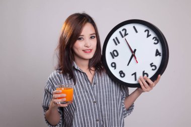 Asyalı kadın saati içki portakal suyu ile.