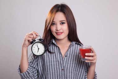 Domates suyu ve saat ile genç Asyalı kadın.