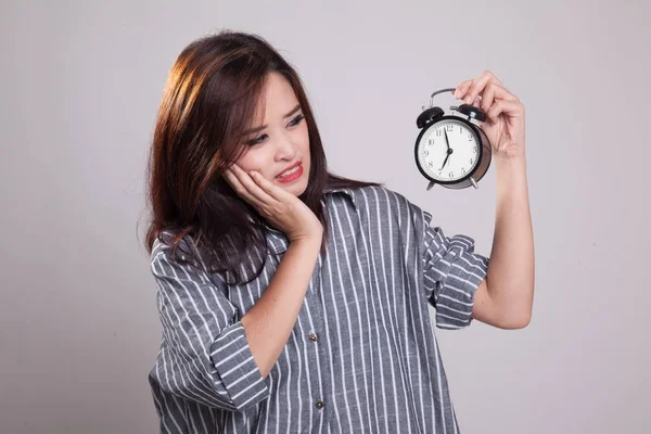 Jonge Aziatische vrouw wordt benadrukt met een klok. — Stockfoto