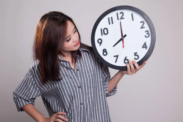 Young Asian woman with a clock. — Stock Photo, Image