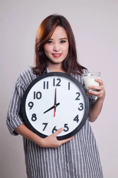 Saludable mujer asiática bebiendo vaso de leche celebrar reloj . — Foto de Stock