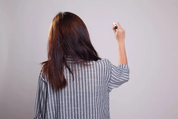 Costas da menina asiática escrever no ar com uma caneta marcador — Fotografia de Stock