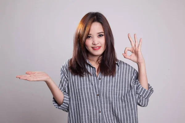 Güzel genç Asyalı kadın göstermek palm el ve Ok işareti. — Stok fotoğraf