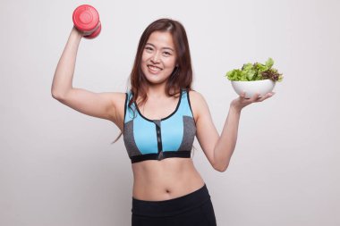Güzel Asyalı sağlıklı kız dumbbell ve salata ile.