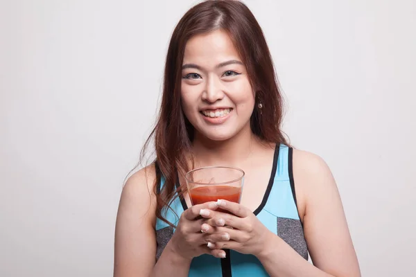 Beautiful healthy Asian girl with tomato juice. — Stock Photo, Image