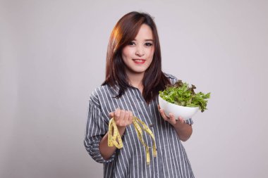 Ölçme bant ve salata ile sağlıklı Asyalı kadın.