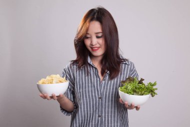 Patates kızartması ve salata ile genç Asyalı kadın.