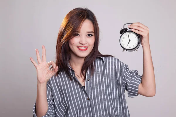 Mladá asijská žena Ukázat Ok s hodinami. — Stock fotografie