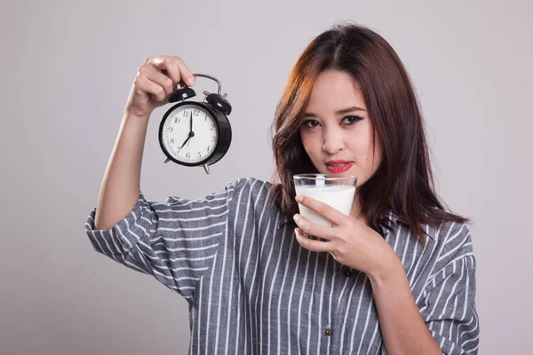 健康的亚洲女人喝杯牛奶举行时钟. — 图库照片
