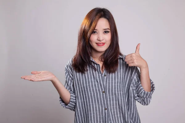 Hermosa joven asiática mostrar la palma de la mano y pulgares hacia arriba . —  Fotos de Stock