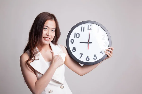 Young Asian woman thumbs up with a clock. — Stock Photo, Image