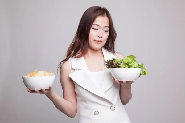 Giovane donna asiatica con patatine e insalata . — Foto Stock