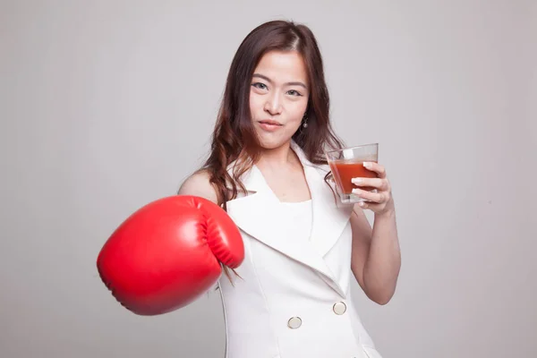 Молодая азиатка с томатным соком и боксёрской перчаткой . — стоковое фото