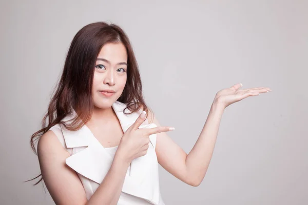 Hermosa joven mujer asiática punto a palma de la mano . — Foto de Stock