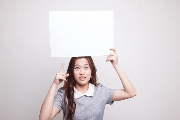 Jonge Aziatische vrouw punt aan leeg teken. — Stockfoto
