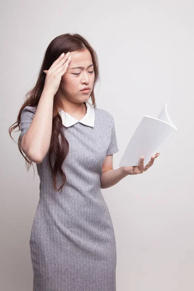 Giovane donna asiatica ha avuto mal di testa leggere un libro . — Foto Stock