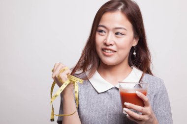 Domates suyu ve ölçüm bandı ile Asyalı kadın.