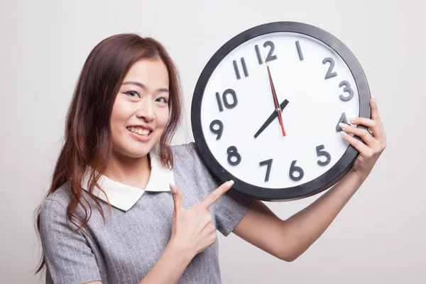 Joven asiática mujer punto a un reloj . —  Fotos de Stock