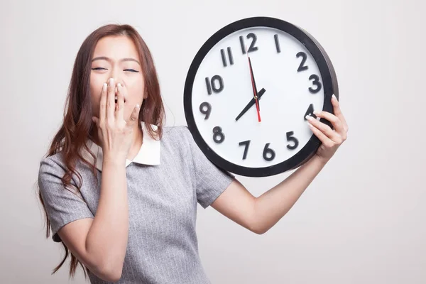 Somnolent jeune femme asiatique avec une horloge le matin . — Photo
