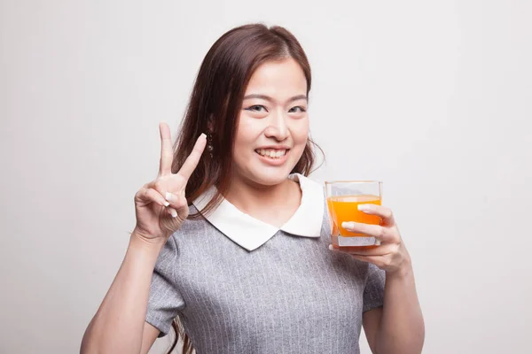 Giovane asiatico donna spettacolo vittoria segno bere arancia succo . — Foto Stock