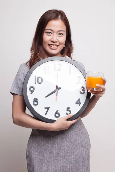 Femme asiatique avec une horloge boisson jus d'orange . — Photo