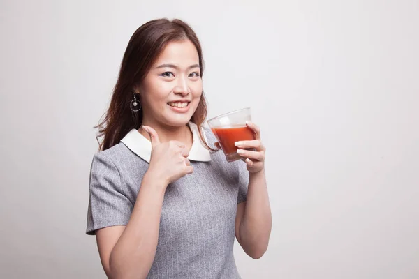 Молодая азиатка поднимает пальцы томатным соком . — стоковое фото