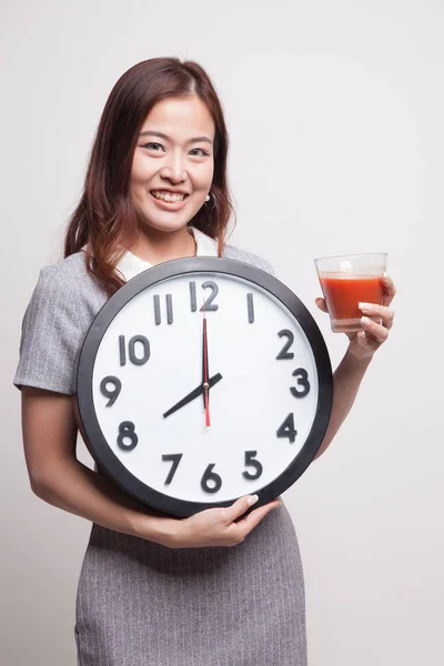 年轻的亚裔女子和番茄汁和时钟. — 图库照片