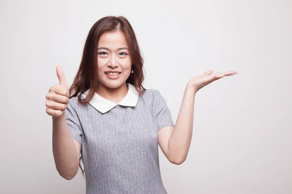 Belle jeune femme asiatique montrer main de palme et pouces vers le haut . — Photo