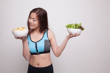 Güzel Asyalı sağlıklı kız salata ve patates cipsi.