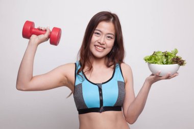 Güzel Asyalı sağlıklı kız dumbbell ve salata ile.