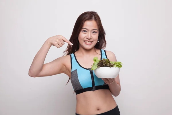 Mooie Aziatische gezond meisje punt aan salade. — Stockfoto