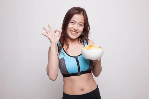 Mooie Aziatische meid van gezond eten potato chips Toon Ok teken. — Stockfoto