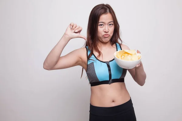 Aziatische gezond meisje duim omlaag met aardappelchips. — Stockfoto