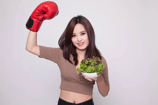 Joven mujer asiática con guante de boxeo y ensalada . — Foto de Stock