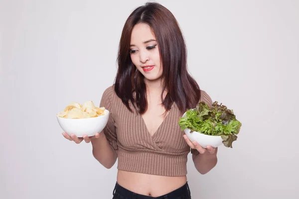 Jovem mulher asiática com batatas fritas e salada . — Fotografia de Stock