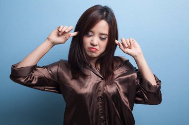 Genç Asyalı kadın parmakları ile her iki kulak engellemek.