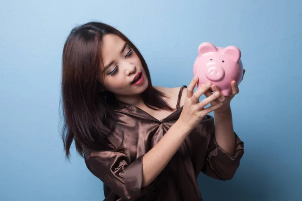 Young Asian woman with a pig coin bank. — Stock Photo, Image