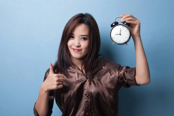 年轻的亚裔女子拇指拿着一个时钟. — 图库照片
