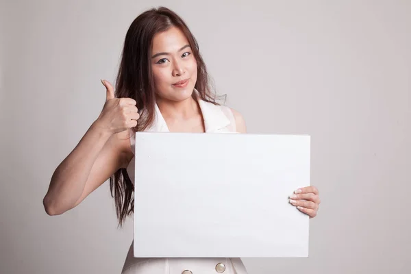 Junge asiatische Frau zeigen Daumen nach oben mit weißen leeren Zeichen. — Stockfoto