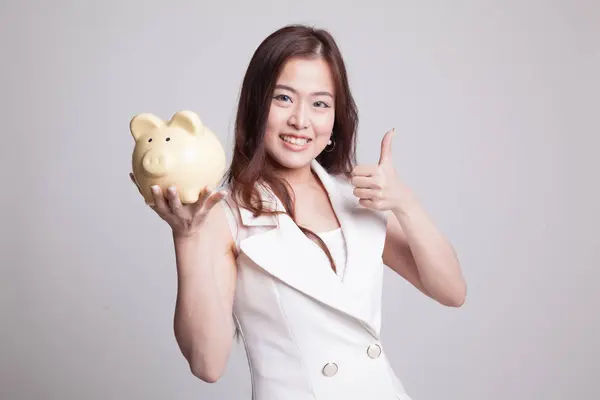 亚洲女人竖起大拇指与猪硬币银行. — 图库照片