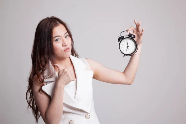 Young Asian woman show thumbs up with a clock. — Stock Photo, Image