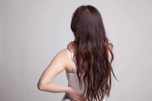 Jovem mulher asiática tem dor nas costas . — Fotografia de Stock