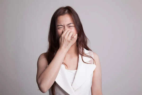 Junge asiatische Frau hält ihre Nase wegen eines schlechten Geruchs. — Stockfoto