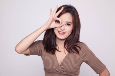 Güzel genç Asyalı kadın göster Tamam gözü üzerinde oturum.