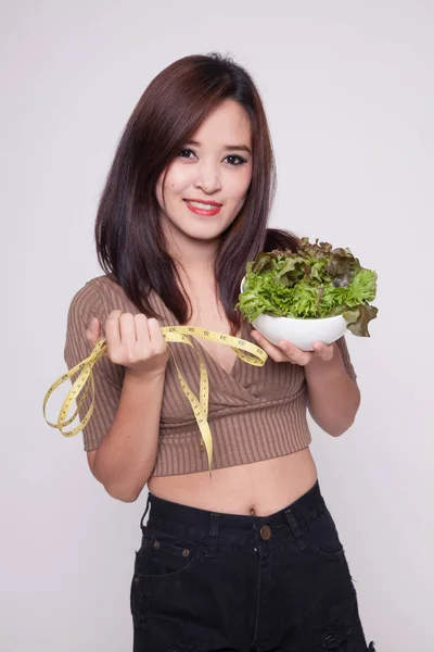 Friska asiatisk kvinna med mätning av tejp och sallad. — Stockfoto