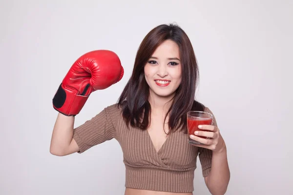 Joven mujer asiática con jugo de tomate y guante de boxeo . — Foto de Stock