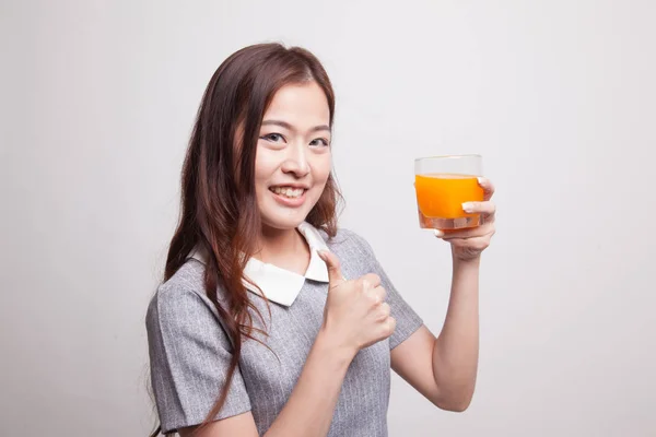 Giovane donna asiatica pollice in su bere succo d'arancia . — Foto Stock
