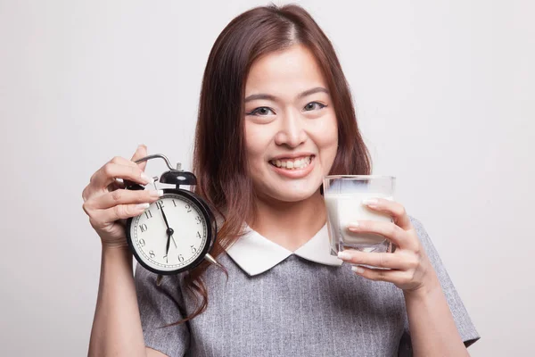 Saludable mujer asiática bebiendo vaso de leche celebrar reloj . — Foto de Stock